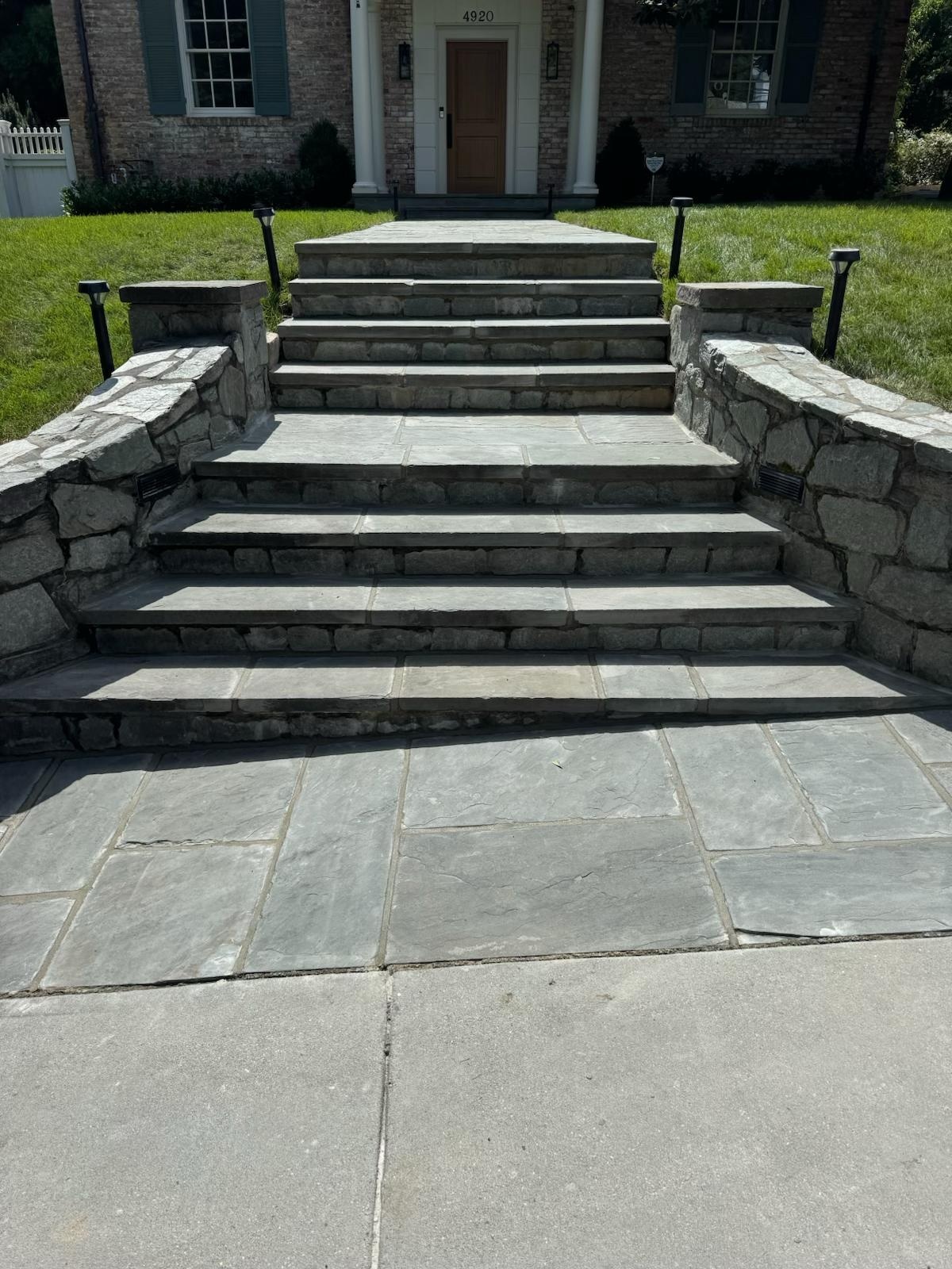 Large stone entry stairs and walkway leading to a front door
