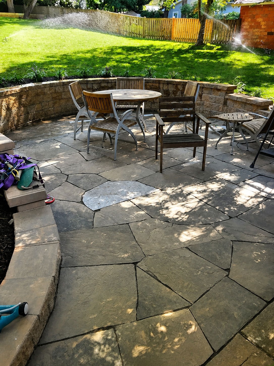 Outdoor stone patio seating area with table and chairs