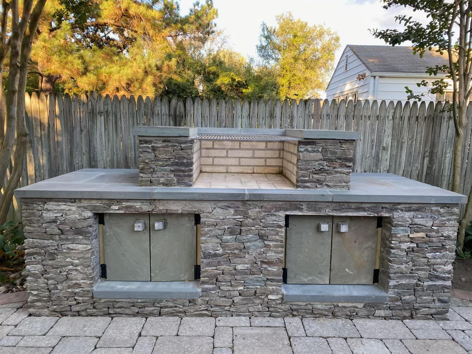 Outdoor stone kitchen and patio feature by Flores Landscaping